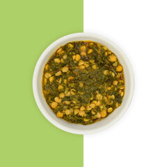 Freshly cooked spicy spinach with Split chickpeas served in a bowl isolated on white and green, Pakistani dish Spinach with Split chickpeas (Palak Daal)