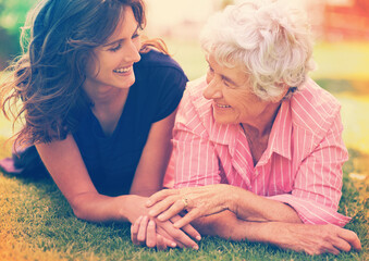 Smile, senior mother and woman holding hands on grass outdoor to relax, support and bonding together. Park, elderly person and adult daughter in garden for connection, relationship and love of family