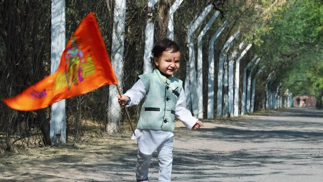 kid walking holy saffron flag with lord rama idol at day from flat angle