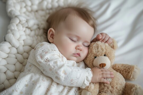 baby boy sleeping on white mattress while hugging teddy bear copy space 