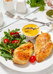 fried chicken breasts with green salad on plate
