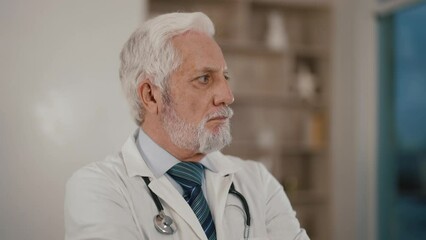 Senior man doctor working on tablet. Professional busy old male in glasses white gown reading medical cards online. Modern medicine, practitioner in office concept. Elderly specialist doing job, work.