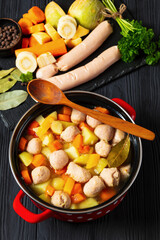 finnish sausage soup with vegetables in red pot