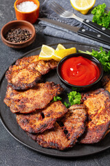 fried juicy pork steaks with ketchup on plate