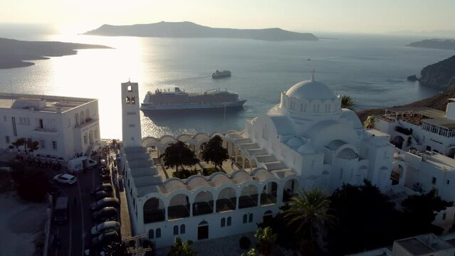 Aerial over Orthodox Cathedral of Fira Revealing Old Harbor Bay Cruises, Santorini, Greece
