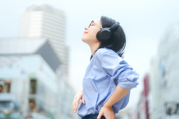  Young adult asian woman wear wireless headphone urban people lifestyles with positive self love