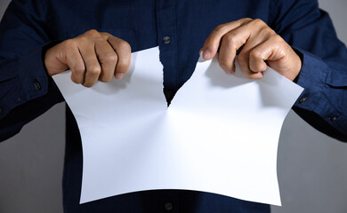 Man tearing blank white paper into two parts. Isolated. With copy space.