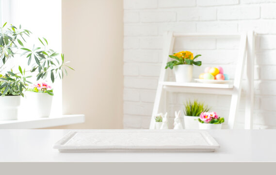 Marble podium tray on white table and blurred room interior background decorated for easter holiday