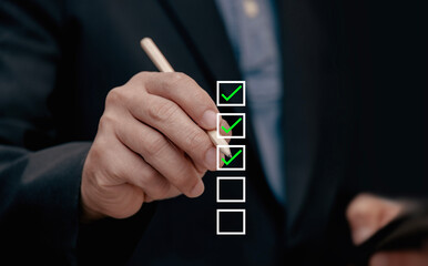 business project approval concept Businessman uses pen by making correct tick in check box to...