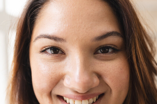 Close-up of a young plus size biracial woman smiling at the camera unaltered