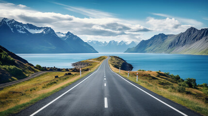 A long straight road with mountains in the background.