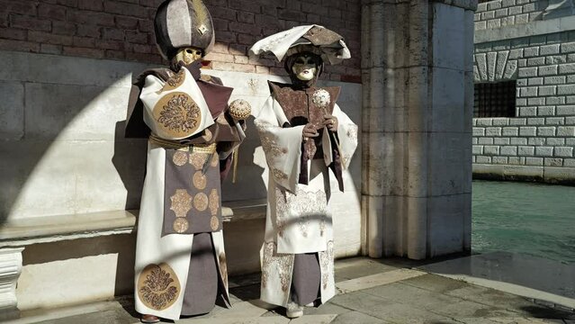 Venice, Italy - February 13, 2024 - carnival masks are photographed with tourists in San Marco square