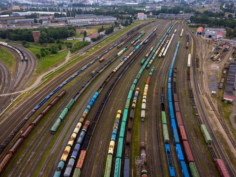 Overhead shot captures a vibrant railway yard bustling with various colorful cargo trains.