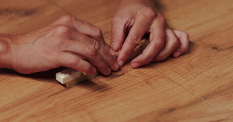 Adult hands assemble plastic toy blocks and play sets.