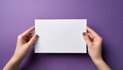 Obraz premium Female hands holding an empty white piece of paper with a purple colorful background. Space for text, copy and other graphics. ai generated.