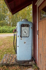 Old vintage gas pump against a wooden wall.