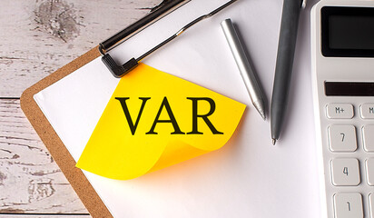 VAR word on yellow sticky with calculator, pen and clipboard - obrazy, fototapety, plakaty