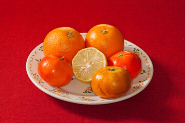 Oranges mandarines et citron coupé dans une assiette au décor fleuri