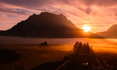 Foggy alpine sunrise view with Mount Zugspitze at Lermoos, Reutte, Tyrol, Austria