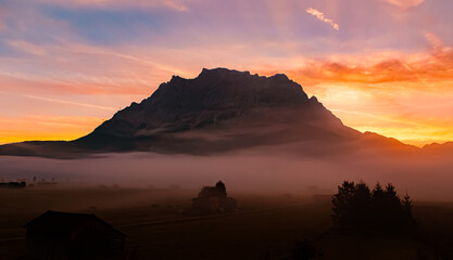 Foggy alpine sunrise view with Mount Zugspitze at Lermoos, Reutte, Tyrol, Austria