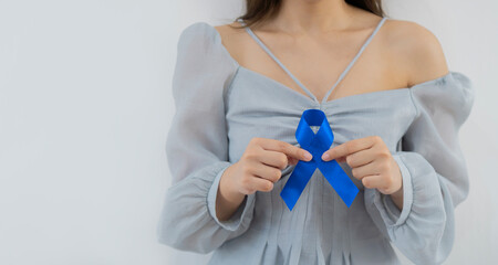 Woman holding blue ribbon on white background. Prostate cancer concept.