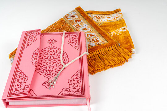 Quran and Muslim rosary beads seen on prayer mat. Ramadan Concept.
