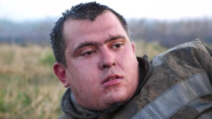 Portrait of tired fireguard with wet face after extinguishing fire at countryside. Exhausted sight of male firefighter after hard work. Concept of saving lives and heroic profession. Close up