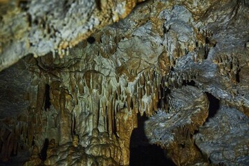 A wild cave inside. Stalactites and stalagmites. Speleology and surveys