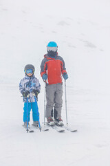 Children and adults, happy family in winter clothing at ski vacation, skiing, winter