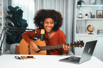 Host channel in musician of young African American playing guitar along with singing, broadcasting...