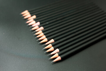Stack of black pencil on the matte black background. Conceptual minimalist black art