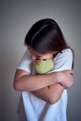 teenage girl with her favorite toy from childhood, a green stuffed turtle