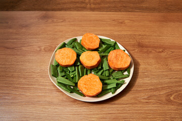 plate with cut green beans and sliced sweet potato