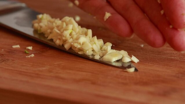 aromatic artistry: woman hands chopping garlic close-up
