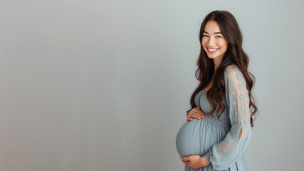 Brunette pregnant woman with pregnancy belly, in soft blue clothes