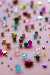 Various colorful beads on bright pink background. Selective focus.