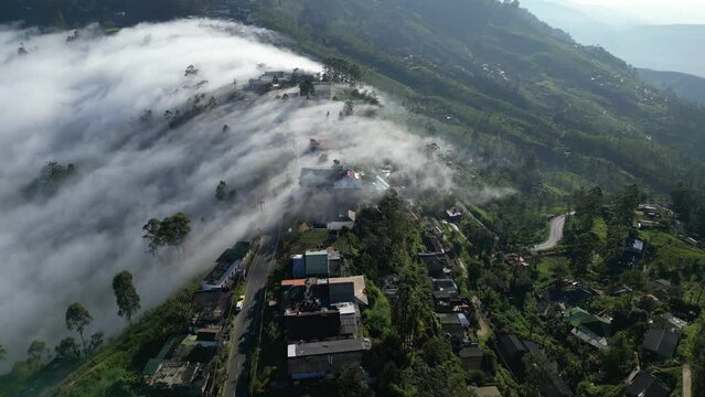 A cloudfall above the mountain village of Haputale in Sri Lanka. Clouds are flowing over the pass. Unusual natural weather phenomenon of falling fog