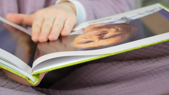 Photo book album. A woman looks at a photo of her father