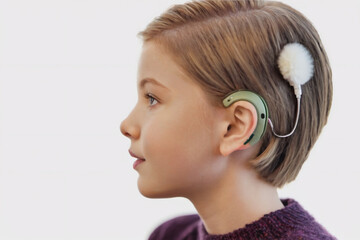 Teen girl with blond hair wearing cochlear implant cover of a fluffy hairpin.