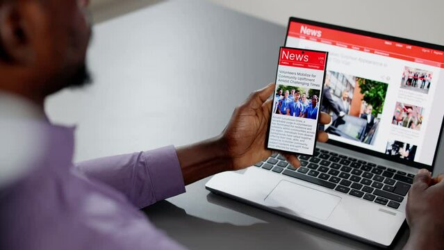Watching Online News Article On Mobile Phone And Laptop