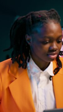 Vertical Video African american student working on her bachelor paper essay at home, writing ideas from online research. Girl exploring digital libraries and academic databases for additional