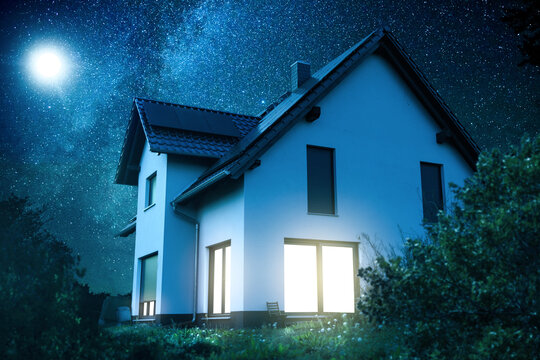 Exterior of an Illuminated Single-Family Home at Night Under a Starry Sky