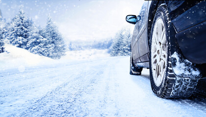 Car tires on winter road covered with snow close-up
