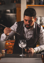 Bartender is adding ingredient in glass