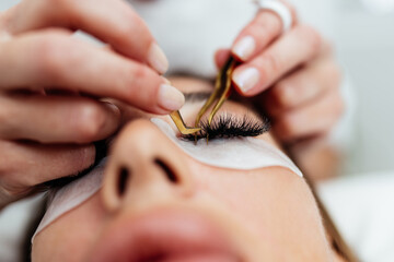 Beautiful young adult woman receiving professional permanent makeup treatment. Modern face and...