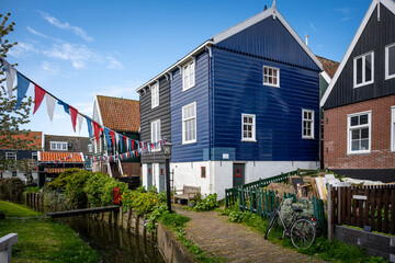 Street filled with flags in the village of Marken with traditional colorful houses in Holland Dutch...