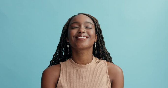 Peace, breathing and happy black woman in studio with gratitude, mindfulness or positive attitude on blue background. Relax, face and African female model with eyes closed zen, smile or stress relief
