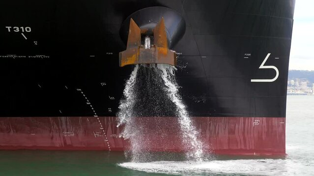 Container ship ballast discharging ballast water out from the Anchor's hub