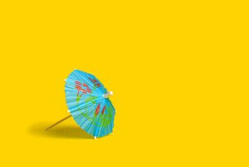 Cocktail umbrellas on yellow background. Summer background with copy space © sandor