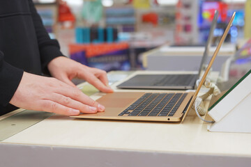 Buyer checking laptops in a computer store